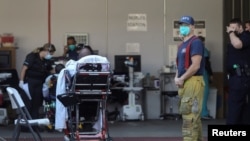 Kru ambulans menunggu untuk menerima pasien di luar pintu masuk darurat Rumah Sakit Komunitas MLK selama lonjakan kasus Covid-19 di Los Angeles, California, AS 26 Desember 2020. (Foto: REUTERS/David Swanson)