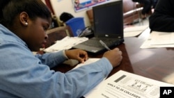 A student at Roosevelt High School fills out a college enrollment application at her school in Washington, D.C., Nov. 14, 2013.