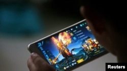 FILE - A child plays the game Honour of Kings by Tencent at home in Dezhou, Shandong province, China, July 2, 2017. 