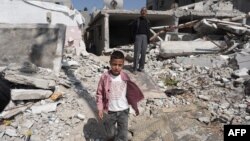 A boy walks amid debris following Israeli bombardment in Nuseirat, central Gaza, on April 12, 2024, amid ongoing battles between Israel and the Palestinian militant group Hamas.
