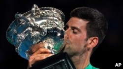 FILE - Serbia's Novak Djokovic kisses the Norman Brookes Challenge Cup after defeating Russia's Daniil Medvedev in the men's singles final at the Australian Open tennis championship in Melbourne, Australia Feb. 21, 2021.(AP Photo/Mark Dadswell)