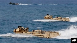FILE - U.S. Navy amphibious assault vehicles with Philippine and U.S. troops on board are seen during joint exercises near a beach facing one of the contested islands in the South China Sea known as the Scarborough Shoal in the West Philippine Sea, April 
