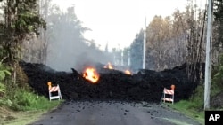 This photo provided by Hawaii Electric Light shows Mohala Street in Leiliani Estates near the town of Pahoa on Hawaii's Big Island that is blocked by a lava flow from the eruption of Kilauea volcano, May 4, 2018. 