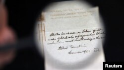 A note written on a Tokyo hotel official paper in 1922 by Albert Einstein is seen before it is sold at an auction in Jerusalem, October 24, 2017. (REUTERS/Ammar Awad)