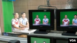 "Rappers Vo Viet Phuong, 25, and Nguyen Trong Duc, 27, record the latest edition of Rap News Plus at Vietnam News Agency's television studio in central Hanoi, Vietnam, July 15, 2014. (Marianne Brown)