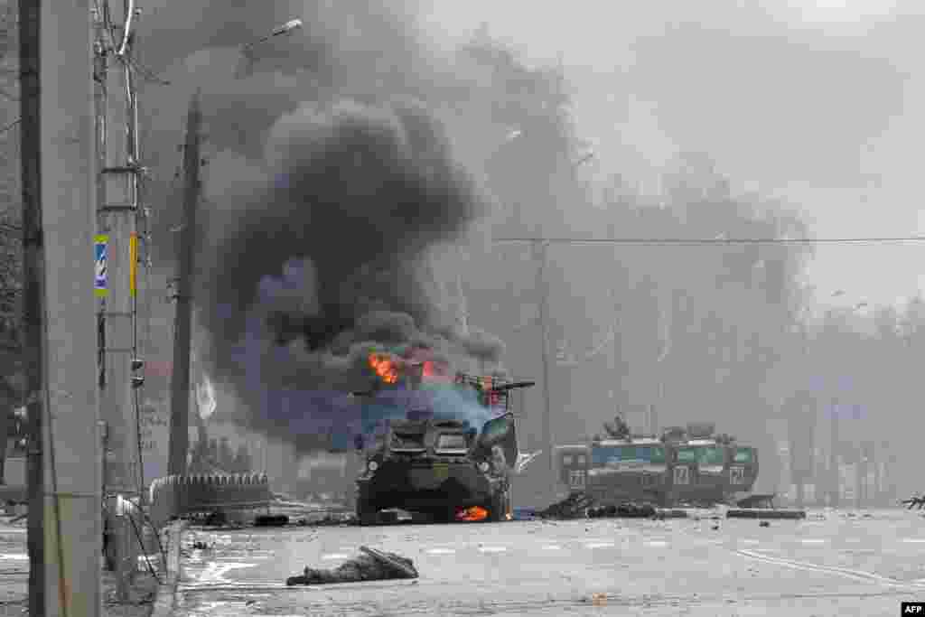 A Russian Armored personnel carrier (APC) burns next to unidentified soldier's body during a fighting with the Ukrainian armed forces in Kharkiv, Feb. 27, 2022.