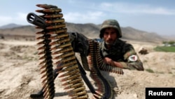 An Afghan National Army soldier holds a position while patrolling the village of But Khak on the outskirts of Kabul, May 15, 2012. 
