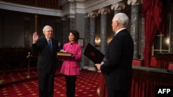 El líder de la mayoría del Senado Mitch McConnell, participa en una ceremonia de juramentación de práctica con el vicepresidente Mike Penc para la instalación del 117 Congreso mientras su esposa la secretaria de Transporte Elaine Cho sostiene una biblia.
