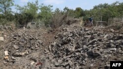 在敖德薩的一處公墓，當地居民站在被俄羅斯導彈炸出的彈坑邊。(2023年7月19日)