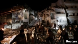 Civilians and civil defense members look for survivors at a site damaged after suspected Russian airstrikes on the Syrian rebel-held city of Idlib, Syria, late May 30, 2016. The strikes killed at least 50 people and left dozens more injured.