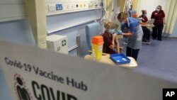 Nurse Katie McIntosh administers an injection of the Pfizer/BioNTech Covid-19 vaccine to Clinical Nurse Manager Fiona Churchill, at the Western General Hospital, in Edinburgh, Scotland, Tuesday Dec. 8, 2020. Key workers and the elderly are among the first to receive a shot of th