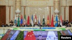 Participants listen to China's President Xi Jinping speaking via a video link during the Shanghai Cooperation Organization (SCO) summit in Dushanbe, Tajikistan, Sept. 17, 2021.