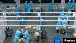 Para profesional medis mengumpulkan sampel dari seorang pria di pusat pengujian komunitas untuk Covid-19 di Hong Kong, Cina 1 September 2020. (Foto: Anthony Kwan via REUTERS)