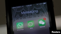 FILE - Icons of messaging applications are seen on the screen of a smart phone on this photo illustration taken in Beijing, February 24, 2014. 