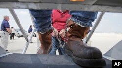FILE - Shackled Mexican nationals are boarded onto a U.S. Immigration and Customs Enforcement jet for deportation, at O'Hare International Airport in Chicago, Illinois, May 25, 2010.
