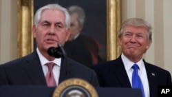 President Donald Trump smiles at Secretary of State Rex Tillerson after he was sworn in in the Oval Office of the White House in Washington, Feb. 1, 2017. 