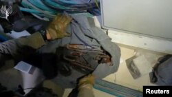 Izraelski vojnik pokazuje oružje i opremu koji su pronađeni u bolničkom kompleksu Al Shifa u Gazi. (Foto: Israel Defense Forces/Handout via REUTERS)