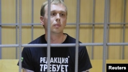 Russian investigative journalist Ivan Golunov, who was detained by police and accused of drug offences, sits inside a defendants' cage as he attends a court hearing in Moscow, Russia, June 8, 2019.