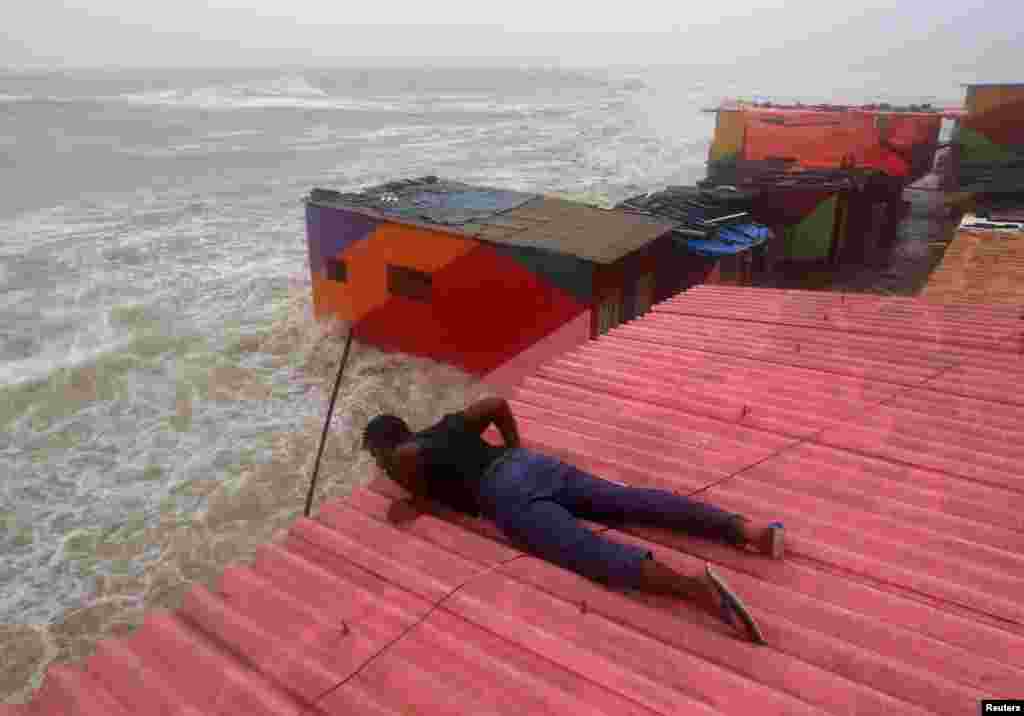 A man inspects his house during high tide at the sea front in Mumbai, India, July 15, 2018.