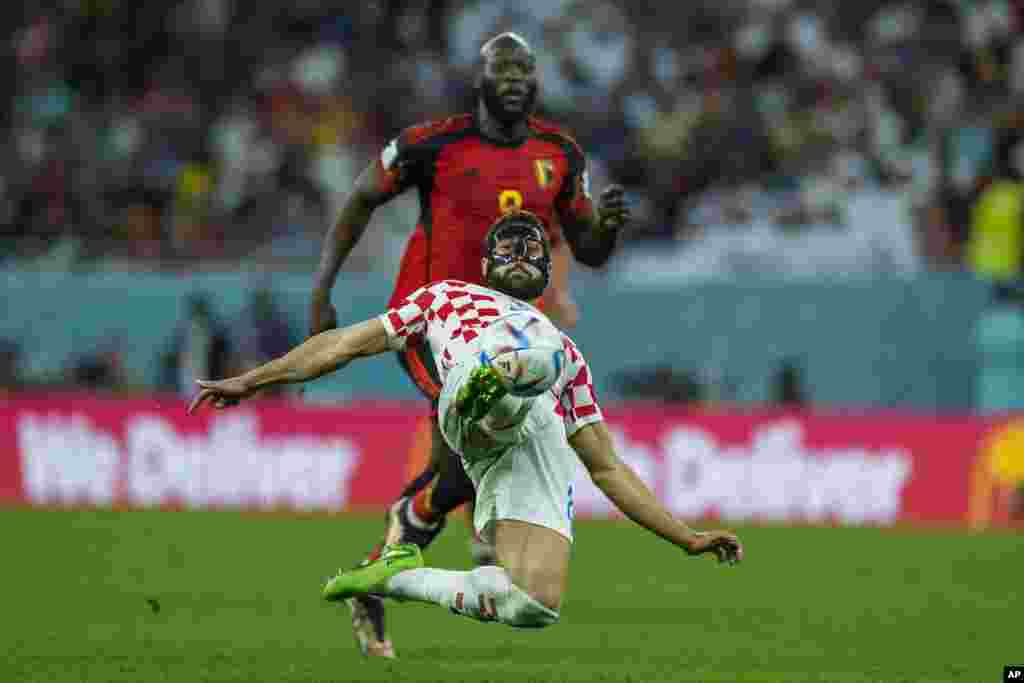 El croata Josko Gvardiol, al frente, patea el balón frente al belga Romelu Lukaku durante el partido de fútbol del grupo F de la Copa Mundial entre Croacia y Bélgica, en el estadio Ahmad Bin Ali de Al Rayyan, Qatar.