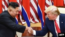 (FILES) In this file photo taken on June 30, 2019, North Korea's leader Kim Jong Un (L) and US President Donald Trump shake hands during a meeting on the south side of the Military Demarcation Line that divides North and South Korea, in the Joint…