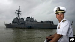 Hung Ba Le, pose devant vu le navire USS Lassen, au large du port de Tien Sa à Danang, au Vietnam, le le 7 novembre 2009.
