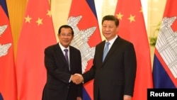 រូបឯកសារ៖ លោកនាយករដ្ឋមន្ត្រី ហ៊ុន សែន ចាប់ដៃ​ជាមួយ​លោក​ប្រធានាធិបតីចិន ស៊ី ជីនពីង មុន​កិច្ចប្រជុំនៅវិមានរដ្ឋាភិបាលចិនប្រចាំទីក្រុង​ប៉េកាំង ប្រទេស​ចិន ថ្ងៃទី២៩ ខែមេសា ឆ្នាំ២០១៩។ (Reuters)