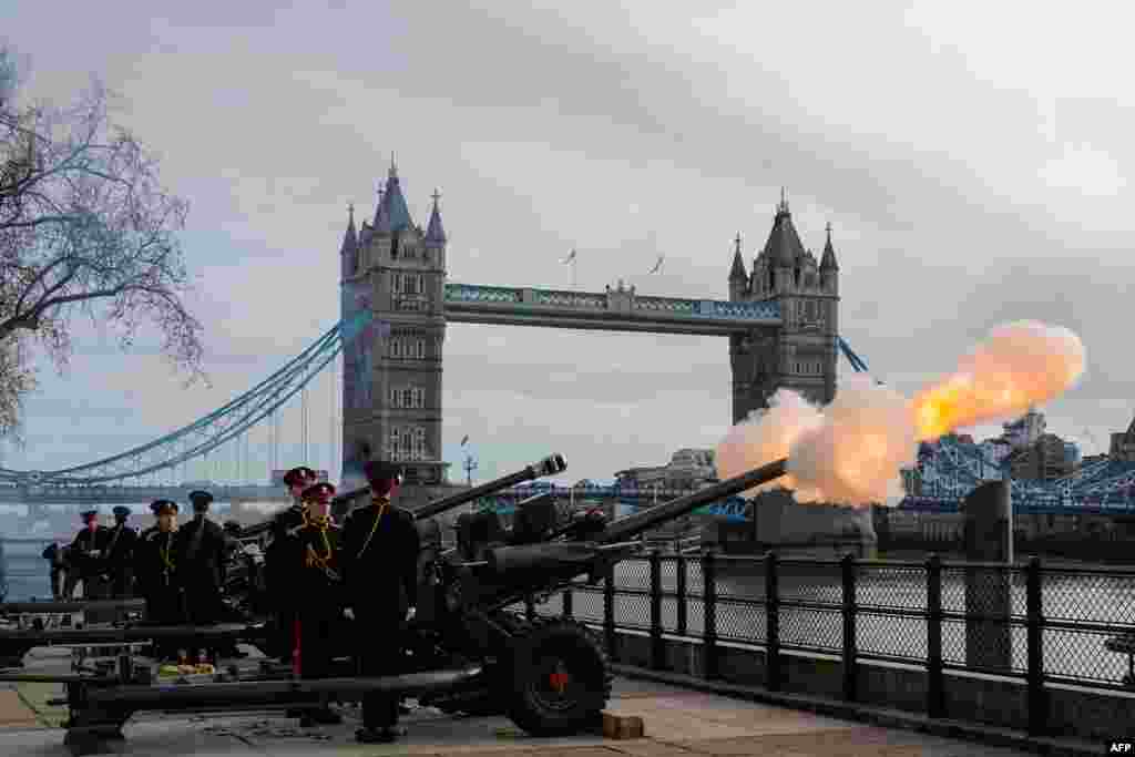 Members of the Honorable Artillery Company fire a gun salute in front of Tower Bridge in London to mark the 70th anniversary of Queen Elizabeth II's accession to the throne.