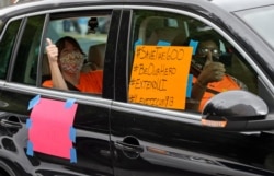 FILE - Motorists take part in a caravan protest in front of Senator John Kennedy's office at the Hale Boggs Federal Building asking for the extension of the $600 in unemployment benefits in New Orleans, La., July 22, 2020.