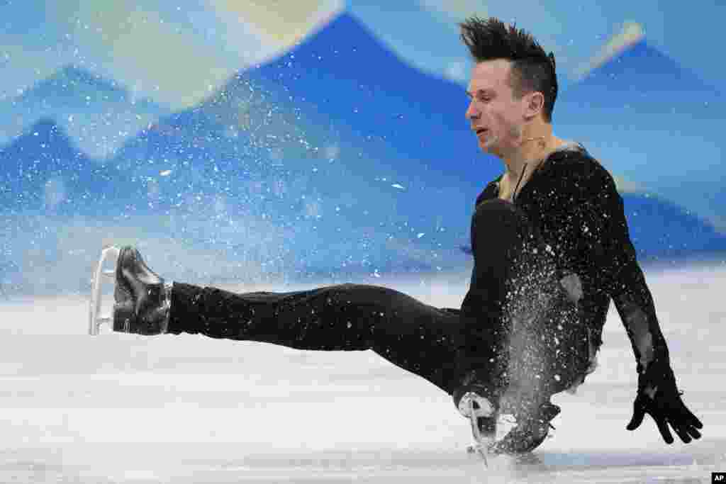 Alexei Bychenko of Israel falls during the men's short program figure skating competition at the 2022 Winter Olympics in Beijing.