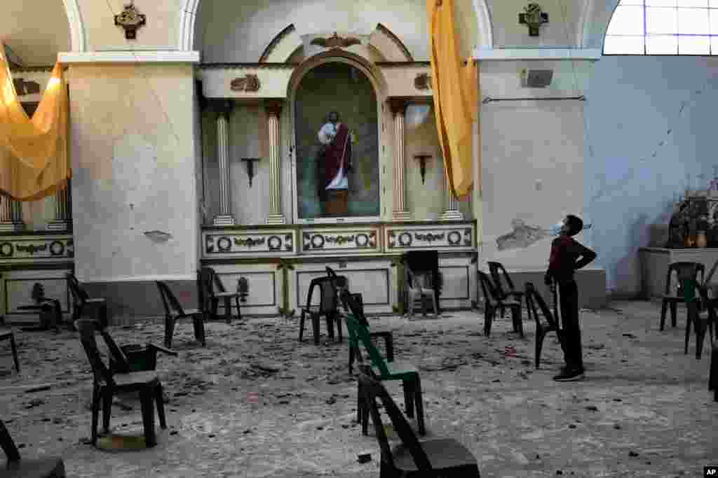 A boy stands in a partially collapsed church triggered by an overnight 6.2-magnitude earthquake in Amatitlan, Guatemala.