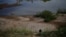 FILE - This Oct. 31, 2019, photo shows a fisherwoman walking on an embankment of the drought-stricken Mekong river in Pak Chom district in the northeastern Thai province of Loei. 