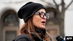 Patricia Oliver, wife of Manuel Oliver, speaks as her husband Manuel displays a banner calling for gun violence prevention from a construction crane near the White House on Feb.14, 2022. Oliver's son Joaquin Oliver was killed in the Parkland School shooting.