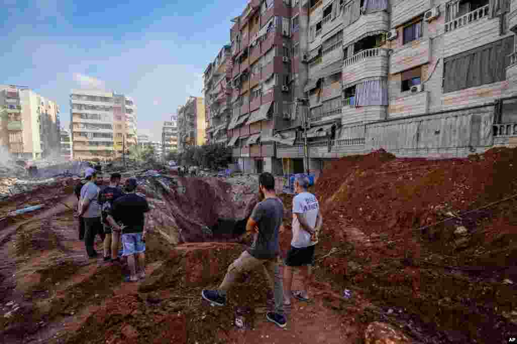 People gather at the site of the assassination of Hezbollah leader Hassan Nasrallah in Beirut's southern suburbs, Lebanon.