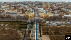 រូបឯកសារ៖ ក្រុម​បាតុករនាំគ្នា​កាន់​ទង់ជាតិ​ធំ​មួយ​របស់​ប្រទេស​អ៊ុយក្រែន​នៅ​តាម​ដង​ផ្លូវ​ក្នុង​ទីក្រុង Odessa ប្រទេស​អ៊ុយក្រែន ថ្ងៃទី២០ ខែកុម្ភៈ ឆ្នាំ២០២២។ (AP Photo/Emilio Morenatti)