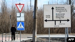 Muškarac prolazi pored putokaza u gradu Avdiivka, u oblasti Donjecka, koji se nalazi na liniji fronta sa separatistima koje podržava Rusija, 21. februara 2022.