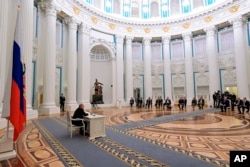 Russian President Vladimir Putin, left, chairs a Security Council meeting in the Kremlin in Moscow, Russia, Feb. 21, 2022.