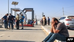 ภาพชายคนหนึ่งที่นั่งพักใกล้ประตู้เขตผ่านแดนราฟาห์ ที่เชื่อมต่อกับอียิปต์ ทางใตของฉนวนกาซ่า เมื่อวันที่ 3 พ.ย. 2566