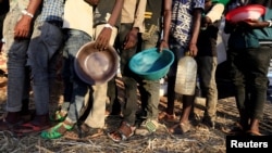 Ethiopian refugees who fled Tigray region, queue to receive food aid within the Um-Rakoba camp in Al-Qadarif state, on the border, in Sudan, Dec. 11, 2020.