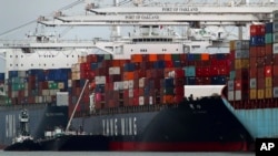 The Yang Ming shipping line container ship Ym Utmost is unloaded at the Port of Oakland on Monday, July 2, 2018, in Oakland, Calif. The Trump administration on Friday, July 6, 2018, will start imposing tariffs on $34 billion in Chinese imports.