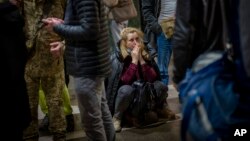 Reakcije žena reaguje dok čeka voz kojim pokušava da napusti Kijev. 