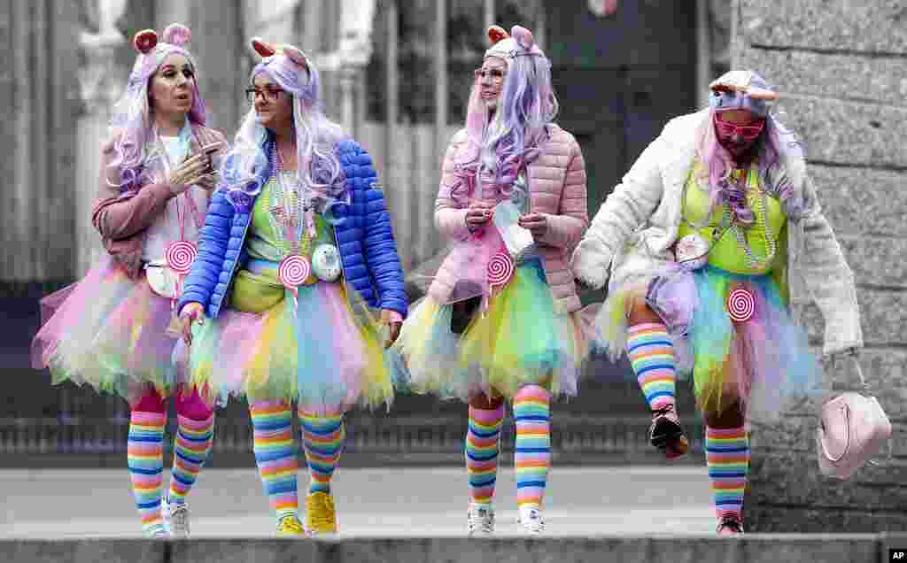 Female revelers walk at the Cologne Cathedral at the start of the street carnival in Cologne, Germany.