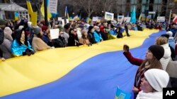 FILE: Pro-Ukraine demonstrators unfurl a large Ukraine flag in a park in New York across the street from the United Nations, Feb. 24, 2022. 