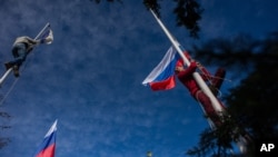 សមាជិក​ម្នាក់​នៃ​កងកម្លាំង​ការពារ​ខ្លួន​ដែល​គាំទ្រ​ប្រទេស​រុស្ស៊ី​​ទម្លាក់​ទង់​កងទ័ព​ជើង​ទឹក​អ៊ុយក្រែន​ខណៈ​ដែល​ម្នាក់​ទៀត​បង្ហូត​ទង់ជាតិ​រុស្ស៊ី នៅ​ឯ​​បញ្ជាការដ្ឋាន​កងទ័ព​ជើង​ទឹក​អ៊ុយក្រែន​នៅ​​ទី​ក្រុង Sevastopol ឧបទ្វីប​គ្រីមា កាល​ពី​ថ្ងៃ​ទី​១៩ ខែ​មីនា ឆ្នាំ​២០១៤។