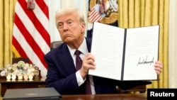 ARCHIVO - El presidente de Estados Unidos, Donald Trump, sostiene una orden ejecutiva firmada sobre inteligencia artificial, en la Oficina Oval de la Casa Blanca, en Washington, Estados Unidos, el 23 de enero de 2025.