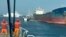 In this photo made from video released by the Taiwan Coast Guard, Taiwanese Coast Guard vessels prepare to board Togolese-flagged cargo ship Hongtai suspected of severing an undersea communications cable, Feb 25, 2025. 
