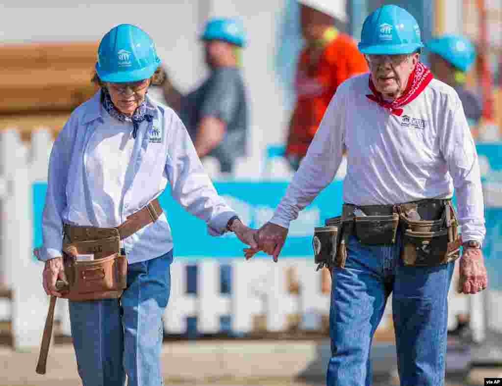 Поранешниот претседател Џими Картер се држи за рака со неговата сопруга Розалин Картер додека тие работат со други волонтери за Хабитат за човештвото во Мишавака, Индијана, на 27 август 2018 година. (Роберт Френклин/Трибина Саут Бенд)