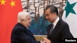 中國外長王毅和敘利亞副總理兼外長瓦利德·穆阿利姆2019年6月18日在北京釣魚台國賓館舉行記者會後握手。