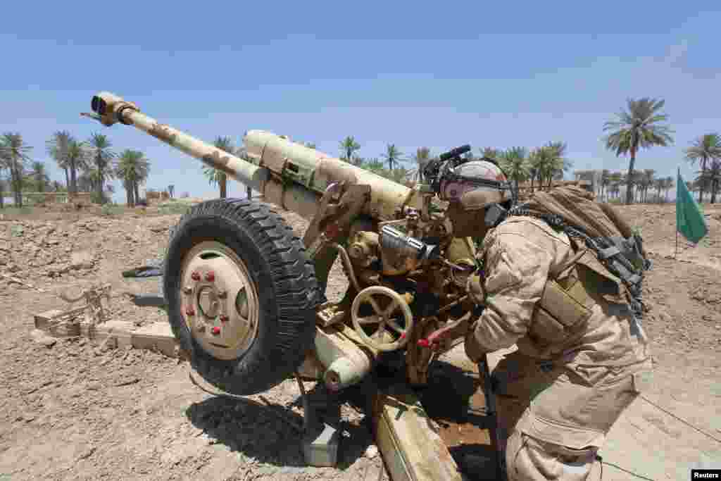 Iroq xavfsizlik kuchlari Jurf al-Saxarda "Iroq va Shom islomiy davlati" jangarilari bilan o'q almashmoqda, 14-iyun, 2014-yil.