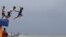 Boys jump into the water despite strong waves after a strong downpour at Manila's bay, Philippines.